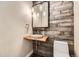 Unique powder bathroom with wood paneling and a live edge countertop at 8280 Bannock Dr, Larkspur, CO 80118