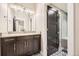 Bathroom featuring a modern vanity and stylish mirrors adjacent to a sleek shower with a glass door at 8280 Bannock Dr, Larkspur, CO 80118