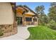 Inviting front porch and entry to this home has stone accents and a manicured lawn at 8280 Bannock Dr, Larkspur, CO 80118