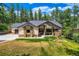 Craftsman style home with beautiful stone accents, a well manicured lawn, and a side entry two car garage at 8280 Bannock Dr, Larkspur, CO 80118