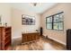 Bright home office with wood floors, a large window, and a decorative cabinet at 8280 Bannock Dr, Larkspur, CO 80118