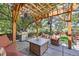 Outdoor patio with wooden pergola, fire table, and stainless steel gas grill at 7445 Shoreham Pl, Castle Pines, CO 80108