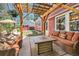 Inviting backyard patio with wooden pergola, string lights, fire table, and comfortable seating at 7445 Shoreham Pl, Castle Pines, CO 80108