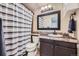 Cozy bathroom features a shower with striped curtain, mosaic tile countertop, and dark wood vanity at 7445 Shoreham Pl, Castle Pines, CO 80108