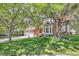 Beautiful two-story home with a well-manicured lawn and mature trees at 7445 Shoreham Pl, Castle Pines, CO 80108