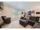 Bright living room with large windows, comfortable seating, and open access to the kitchen at 7445 Shoreham Pl, Castle Pines, CO 80108