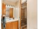 The bathroom features a single sink vanity, shower with glass doors, and decorative lighting at 8745 Yukon St # 30, Arvada, CO 80005
