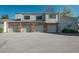 Townhome garages with brick accents and neutral siding, complemented by a paved driveway at 8745 Yukon St # 30, Arvada, CO 80005