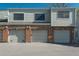 Exterior view of multiple garages with brick accents and gray doors under a blue sky at 8745 Yukon St # 30, Arvada, CO 80005