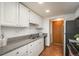 Efficient kitchen with white cabinets, granite counters, stainless steel appliances, and convenient laundry area at 8745 Yukon St # 30, Arvada, CO 80005