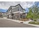Beautiful modern home featuring mixed siding, brick accents, a unique garage door window, and a welcoming outdoor patio at 10117 Morrison Rd, Lakewood, CO 80227