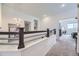 Upstairs hallway with modern lighting, dark wood railings, and access to bedrooms and living areas at 10117 Morrison Rd, Lakewood, CO 80227