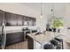 Modern kitchen with sleek dark cabinets, granite countertops, stainless steel appliances, and stylish pendant lighting at 10117 Morrison Rd, Lakewood, CO 80227