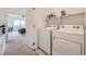 Convenient laundry room adjacent to the bedroom with modern appliances and ample shelving space at 10117 Morrison Rd, Lakewood, CO 80227