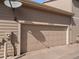 Two car garage with tan door, labeled with house number, with neutral colored siding at 10105 Grove Loop # D, Westminster, CO 80031