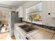 Kitchen featuring granite countertops, tile backsplash and stainless sink at 10105 Grove Loop # D, Westminster, CO 80031