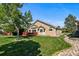 Backyard with a red-stained deck, lush lawn, mature landscaping, and exterior of the home at 9561 Silver Hill Cir, Lone Tree, CO 80124