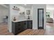 Corner bar area with marble counters, dark cabinets and decorative shelving is close to the entry at 9561 Silver Hill Cir, Lone Tree, CO 80124