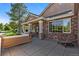 Relaxing covered front porch area with seating and brick columns at 9561 Silver Hill Cir, Lone Tree, CO 80124