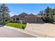 Well-maintained home exterior with a three-car garage, manicured lawn, and mature landscaping at 9561 Silver Hill Cir, Lone Tree, CO 80124