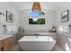 This bright main bath features an eye-catching light fixture and soaking tub at 9561 Silver Hill Cir, Lone Tree, CO 80124