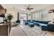 Cozy living room featuring a large blue sectional sofa, a plush rug, and natural light from the sliding patio door at 16828 E Gunnison Dr # 7H, Aurora, CO 80017