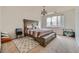 Serene main bedroom featuring a large window, stylish chandelier, and comfortable queen-sized bed with neutral decor at 16828 E Gunnison Dr # 7H, Aurora, CO 80017