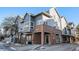 Gray two-story townhome with brick accents and a small patio at 1330 S Monaco Pkwy # 3, Denver, CO 80224