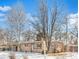 Single-story house featuring a brick exterior with a red door, complemented by bare trees at 6090 Cody St, Arvada, CO 80004