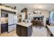 Bright kitchen featuring an island, stainless refrigerator, and an adjacent dining area at 11357 Iola St, Commerce City, CO 80640