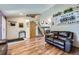 Open-concept living room featuring hardwood floors, a comfortable sofa, and stairs to the second floor at 11357 Iola St, Commerce City, CO 80640