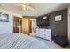 Well-lit bedroom with a TV, ensuite bathroom, and neutral color scheme at 11357 Iola St, Commerce City, CO 80640