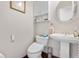 This bathroom features a pedestal sink, toilet, cabinet, and decor at 2925 S Vaughn Way, Aurora, CO 80014