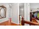 Hallway with hardwood floors leading to bathroom with glass shower and bedroom with ornate furniture at 2925 S Vaughn Way, Aurora, CO 80014
