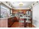 This kitchen features wood cabinets, an island, and a garden window over the sink at 2925 S Vaughn Way, Aurora, CO 80014