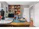 Close-up of an office desk with decor, hardwood floors, and a large shelf at 2925 S Vaughn Way, Aurora, CO 80014