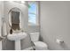 Powder room featuring pedestal sink, toilet, and window offering natural light at 23615 E 5Th Pl, Aurora, CO 80018
