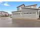 Modern townhome exterior featuring attached two-car garages and contemporary gray siding details at 23615 E 5Th Pl, Aurora, CO 80018