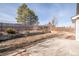 Private fenced backyard with tiered landscaping and mature trees, perfect for outdoor activities at 5857 S Zante Cir, Aurora, CO 80015
