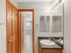 Bathroom with a single sink vanity, wooden cabinets, and a view to another room at 5857 S Zante Cir, Aurora, CO 80015