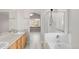 Bathroom showcasing double sinks, bathtub, glass shower, and window at 5857 S Zante Cir, Aurora, CO 80015