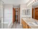 Bathroom featuring double sinks, tub with shower, and linen closet at 5857 S Zante Cir, Aurora, CO 80015