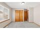Bright bedroom featuring gray carpet, a window, and a closet with wooden doors at 5857 S Zante Cir, Aurora, CO 80015