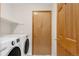 Bright laundry room with a washer, dryer, and shelving for storage at 5857 S Zante Cir, Aurora, CO 80015