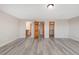 Large, open living room with modern flooring and multiple entryway doors at 5857 S Zante Cir, Aurora, CO 80015