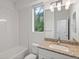 Well-lit bathroom featuring a granite vanity and a tub with white subway tile surround at 11719 W 45Th Pl, Wheat Ridge, CO 80033