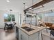 Open floor plan showcases kitchen island, dining area, and living room with abundant natural light at 11719 W 45Th Pl, Wheat Ridge, CO 80033
