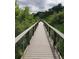 Wood boardwalk through a lush nature area surrounded by greenery and trees at 10157 W 38Th Ave, Wheat Ridge, CO 80033