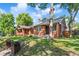 Beautiful exterior view of the classic brick home, surrounded by a lush green lawn and mature trees under a bright sky at 1260 S Emerson St, Denver, CO 80210