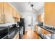 Galley kitchen features wood cabinets, black countertops, and stainless steel appliances at 1260 S Emerson St, Denver, CO 80210